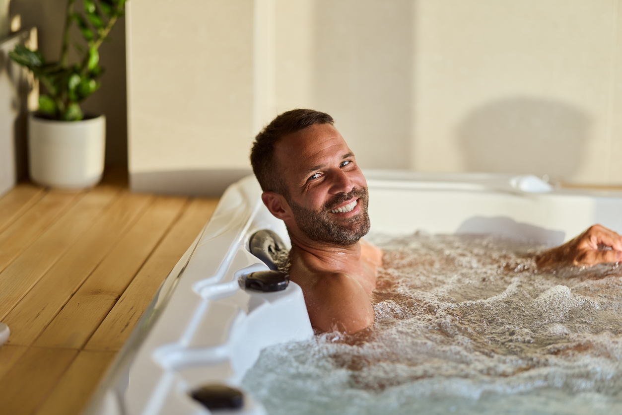 Salt Water Hot Tub Pros and Cons: Man Relaxing in a Bubbling Indoor Spa